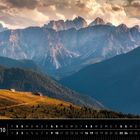 Kalenderseite mit dem Text "Dolomiten 10". Berglandschaft mit Hütten auf einem Bergrücken, im Hintergrund massive Felsen.