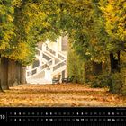 Wien 10 und ein Kalender. Allee mit Herbstlaub, Bänken und einer Treppe im Hintergrund.