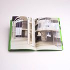 Ein aufgeschlagenes Buch zeigt Fotos von moderner Architektur mit geschwungenen Strukturen und klaren Linien.