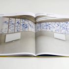 Seite mit Kunstinstallation, blaue abstrakte Malerei an Wandpaneelen, darunter ein Heizkörper.