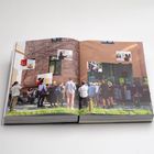 Menschenmenge vor einem Gebäude, Schriftzug "nova space" auf Fenster, Pflanzen im Vordergrund, Wände mit Fotos.