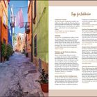 Tipps für Entdecker: Beschreibungen und Kontaktinfos zu lokalen Attraktionen wie Artigianato Pasella und Museo delle Maschere. Bunte Gasse mit farbigen Häusern und aufgehängter Wäsche.