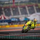 Rennkalender mit einem Motorradfahrer in gelber Ausrüstung, der in einer Kurve fährt; im Hintergrund eine Tribüne.