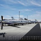 Ein Kalender zeigt einen Monat mit Tagen und Wochentagen. Am Flughafen stehen mehrere Privatjets nebeneinander.