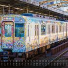Text: "Osaka" in der Zuganzeige, bunte Mosaikgestaltung auf einem Zug, der an einem Bahnhof steht. Kalender unten.
