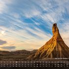 "Bardenas Reales, Navarra 10" über Kalender mit markierten Wochenenden. Majestätische Felsformation unter wolkenreichem Himmel.