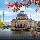 Kalender mit Monatsübersicht und blühenden Kirschblüten vor dem Bode-Museum und Berliner Fernsehturm.