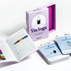 Buch und Karten für Yin Yoga mit Übungen und Tabellen, umgeben von farbigen Darstellungskarten für verschiedene Positionen.