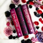 "DIRE BOUND", "SABLE SORENSEN", "THE WOLVES OF RUIN". Drei Bücher mit roten und schwarzen Covern, umgeben von bunten Blumen.