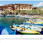 „Gardesana“ steht über einem Hafen mit bunten Booten und einem Gebäude im Hintergrund. Darunter ein Kalender für November.