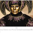 11. Novemberkalender mit kunstvollem Kostüm: Goldene Maske, schwarzes Outfit mit violetten Blumenverzierungen.