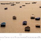 Boote im Abendlicht, November-Kalenderseite, Boote auf schimmerndem Wasser, goldener Himmel, ruhige Atmosphäre.