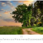 Kalender mit Monat 11, Casares Edition. Ein Weg führt durch eine grüne Wiese, flankiert von Bäumen unter bewölktem Himmel.