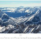 "Österreich, Tiroler Alpen", November-Kalender. Schneebedeckte Berge erstrecken sich in die Ferne unter einem klaren Himmel.