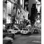 Times Square bei Nacht mit beleuchteten Reklametafeln und fahrenden Autos. Unten Kalender mit Tagen im November.