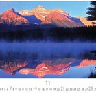 "Schweden, See in Lappland; 11. Kalender mit Bergen im Sonnenuntergang und Spiegelung im See, umgeben von Bäumen."