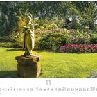"11" und "CASARES EDITION". Eine Statue steht auf einem Sockel inmitten eines üppigen Gartens mit bunten Blumen.