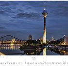 Text: "Medienhafen", "11", Zahlen 1-30. Abendaufnahme des Rheinturms und modernem Gebäudeensemble bei Dämmerung.