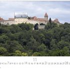 Coburg, Festung Coburg. Monatskalender mit November-Highlight. Historische Burg auf hügeligem, dicht bewaldetem Gelände.