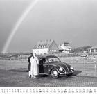 Text: „Ausfahrt“. Schwarz-Weiß-Foto mit zwei Personen neben einem Käfer vor einem Regenbogen und Häusern im Hintergrund.