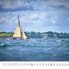 Zahl „11“ unten links, darunter Kalendertage. Segelboot auf bewegtem Wasser, im Hintergrund eine grüne Küstenlandschaft.