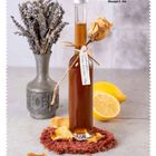 Lavendel-Rosenblüten-Sirup (Rezept S. 94). Eine Flasche Sirup mit Deko aus getrockneten Blumen neben einer Vase und Zitrone.