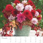 "November" steht oben, darunter ein Kalender. Ein Korb voller roter und pinker Blumen mit Herbstblättern ist zu sehen.