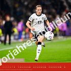 „VORJAHRESABBILDUNG“ über Fußballerin in weißem Trikot mit Nummer 17 im Spiel. Atmosphäre lebendig.