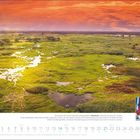 November. Über dem Okavangodelta in Botswana leuchtet der Himmel rot. Landschaft mit grünen Pflanzen. Zwei lachende Kinder.