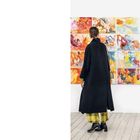 Besucher*innen im Atelier Frackmann, "Flexibel Fundgrube, 2025". Eine Frau betrachtet bunte Gemälde an der Wand.