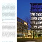 "TAZ VERLAGSHAUS" in blau. Gebäude mit moderner, verglaster Fassade und diagonalen Stahlstützen bei Nacht.