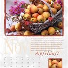 November. Apfelduft. Ein Korb mit Äpfeln, lila Blumen und Dekor. Darunter ist ein Kalendarium für den Monat November.