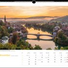 November. Sonnenaufgang über Laufenburg am Rhein. Kalender mit Brücke über Fluss, umgeben von Häusern und sanften Hügeln.