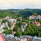 "LAND UND LEUTE" oben, "Blick auf Karlsbad" rechts unten. Hügelige Stadtlandschaft mit vielen Bäumen und gepflegten Gebäuden.