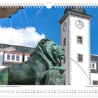 Text: "Löwenfigur am Brunnen 'Otto der Reiche' auf dem Obermarkt. November. 01.11. Allerheiligen, 17.11. Buß- und Bettag." 
Im Hintergrund ein Turm mit Uhr, blauer Himmel.