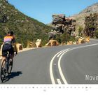 "November"; Kalenderspiralbild zeigt einen Radfahrer auf Bergstraße, umgeben von grünen Hügeln und Felsen. Logo in der Ecke.
