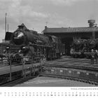 Text oben: "18 323", "Achtung! Bei Annäherung der Lokomotive Traghölzer entfernen". Unten: "NOVEMBER". Schwarze Dampfloks im Bahnbetriebswerk.