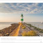 November 2027 | Schleswig-Holstein. Ein weiß-grüner Leuchtturm auf einer Mole, daneben das Meer bei Sonnenuntergang.