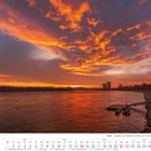 "Bonn - Morgenrot am Rheinufer mit Blick zum Posttower." Ein Kalenderblatt mit einem beeindruckenden Sonnenaufgang über einem Fluss.