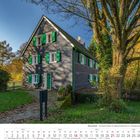 "Remscheid - Hermannsühle im Diepmannsbachtal in Lüttringhausen." Ein Fachwerkhaus mit grünen Fensterläden, umgeben von Bäumen.