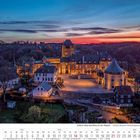 „Schloss Burg und Burg an der Wupper“. Eine beleuchtete Burglandschaft im Abendrot, umgeben von Bäumen. Darunter ein Kalender.