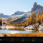 Kalender: Dolomiten, 11. Oktober 2023, Herbstsee, Berge und Lärchen, leicht verschneit, Hütte am Seeufer.