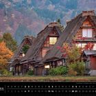 Japan 11. Traditionelle Gassho-Zukuri-Häuser in Shirakawa-go vor einem herbstlichen Waldhintergrund.