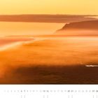 11, Kalenderdaten unten, Landschaft in orange-gelb. Küstenlinie im Nebel, Hügel im Hintergrund. Abendszene.