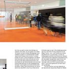 Seite 105. Ein heller Raum mit orangenem Boden. Menschen bewegen sich an Gittern vorbei. Text unten beschreibt ein Schulkonzept.