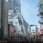Kalender mit November-Tagen unten, Feuerwehrleute auf einer Leiter vor einem Gebäude mit viel Rauch.