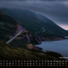 "Nova Scotia im Nebel 11" und Kalendarium; Straße schlängelt sich durch neblige, bewaldete Berge am Meer entlang.