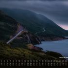 Nova Scotia im Nebel, 11. Küstenstraße entlang bewaldeter Hügel, Meer rechts, dunkle Wolken oben. Kalender unten.