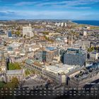 "Aberdeen - Panorama 11". Kalenderübersicht unten. Stadtansicht von oben mit Gebäuden, einer Kirche, Küste und Windrädern.