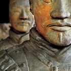 Zwei detailreiche Terrakotta-Krieger, einer im Vordergrund und einer unscharf im Hintergrund.